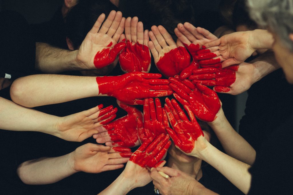 mains jointes avec un coeur peint sur les paumes